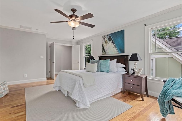 bedroom featuring multiple windows, crown molding, ceiling fan, and light wood-type flooring