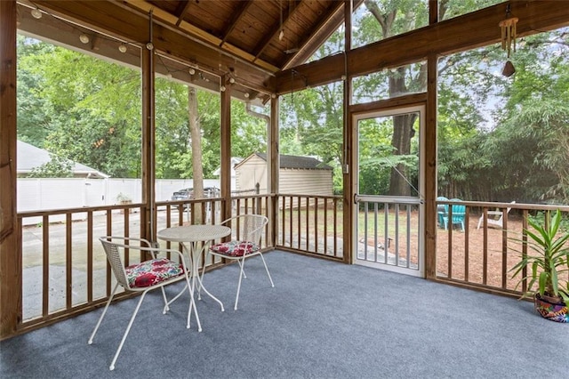 unfurnished sunroom featuring wood ceiling and vaulted ceiling with beams