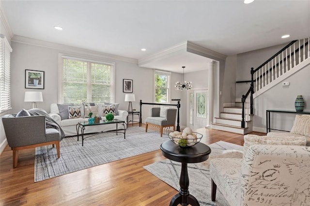 living room featuring ornamental molding, a chandelier, and light wood-type flooring