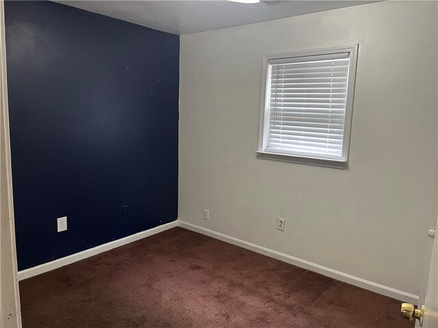unfurnished room with carpet flooring, a chandelier, and baseboards
