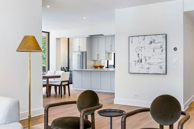 kitchen with beverage cooler, light wood finished floors, gray cabinetry, a sink, and floor to ceiling windows