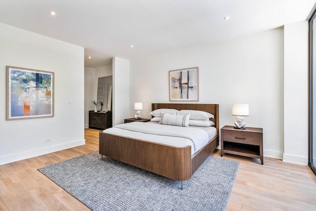 bedroom featuring wood finished floors and expansive windows