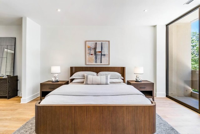 bedroom featuring access to exterior, recessed lighting, light wood-style flooring, and baseboards