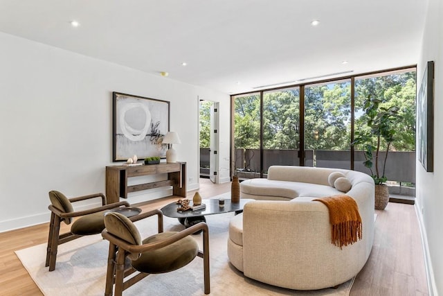 living room featuring expansive windows, recessed lighting, light wood-type flooring, and baseboards