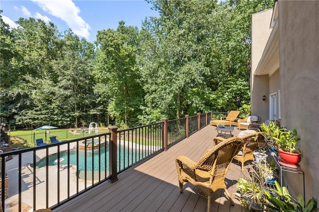 wooden terrace featuring a lawn and a fenced in pool