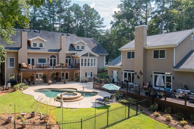 rear view of house featuring a chimney, a fenced backyard, stucco siding, french doors, and a lawn