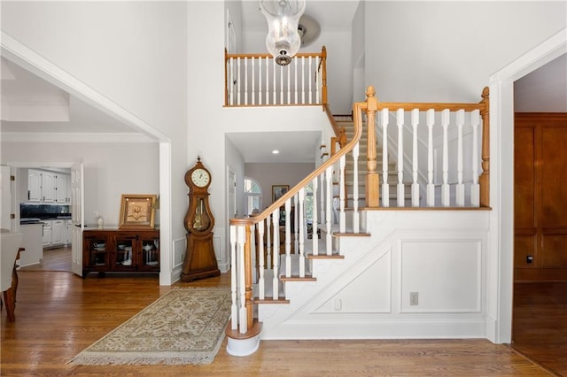 stairway featuring ornamental molding and hardwood / wood-style flooring