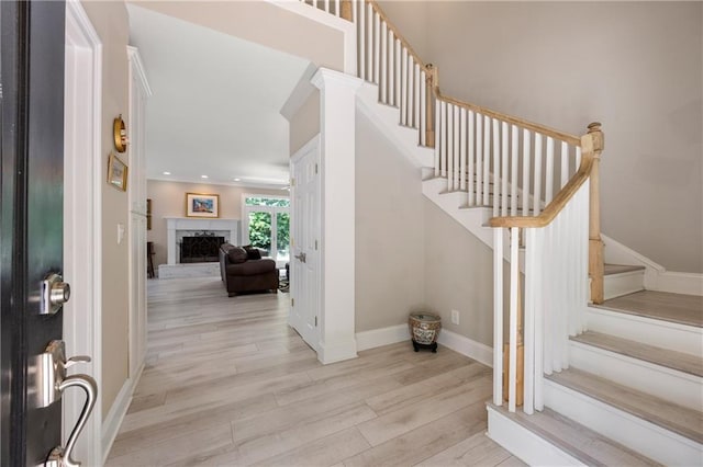 foyer entrance with light wood-type flooring and a fireplace