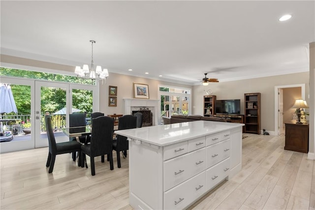 kitchen with white cabinetry, hanging light fixtures, a healthy amount of sunlight, and a center island