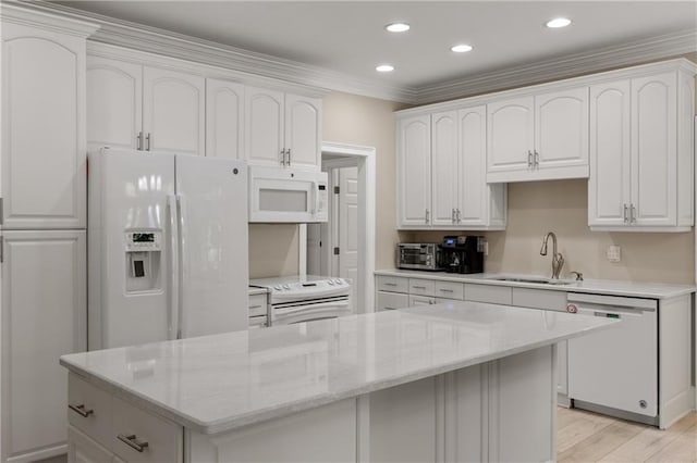 kitchen with ornamental molding, sink, light wood-type flooring, a kitchen island, and white appliances