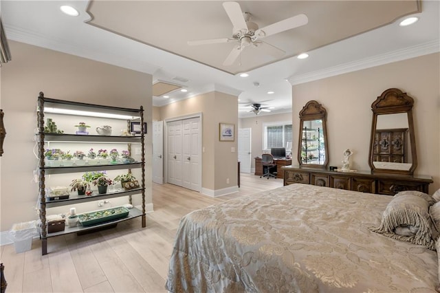 bedroom with a closet, ceiling fan, light hardwood / wood-style floors, and crown molding