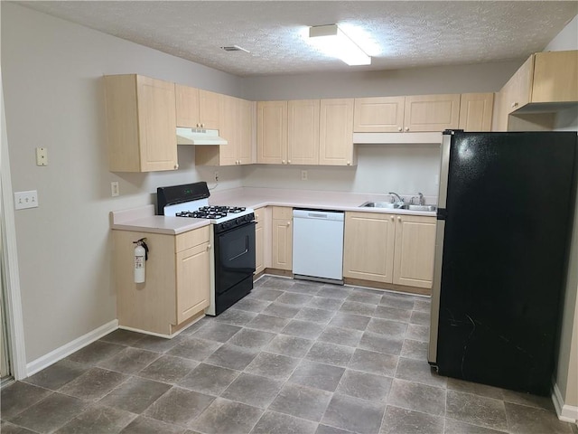 kitchen featuring light brown cabinets, under cabinet range hood, black gas stove, freestanding refrigerator, and white dishwasher