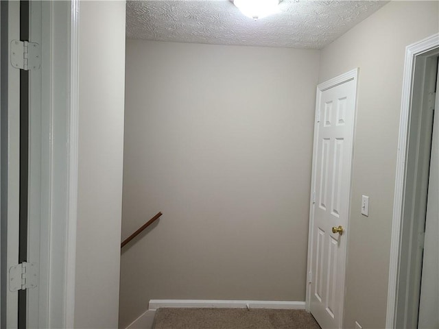 staircase with baseboards and a textured ceiling