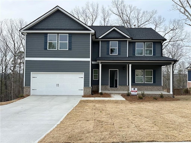 view of front facade with a garage, brick siding, covered porch, and driveway