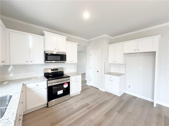 kitchen with light wood-type flooring, stainless steel appliances, light stone countertops, and ornamental molding