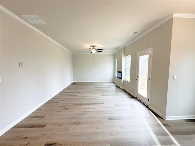 spare room featuring visible vents, baseboards, light wood-style floors, and ornamental molding