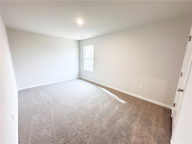 unfurnished room with baseboards and carpet