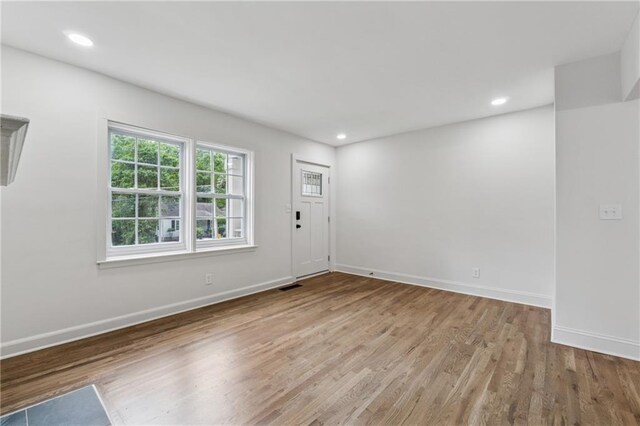 interior space with wood finished floors, recessed lighting, visible vents, and baseboards