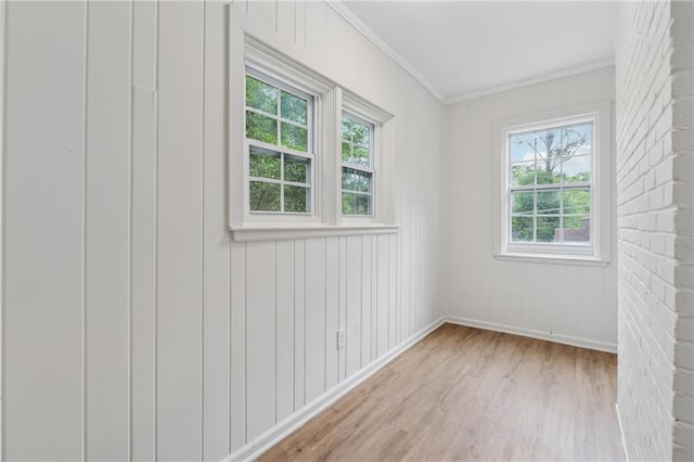 unfurnished room with crown molding, wood finished floors, and baseboards