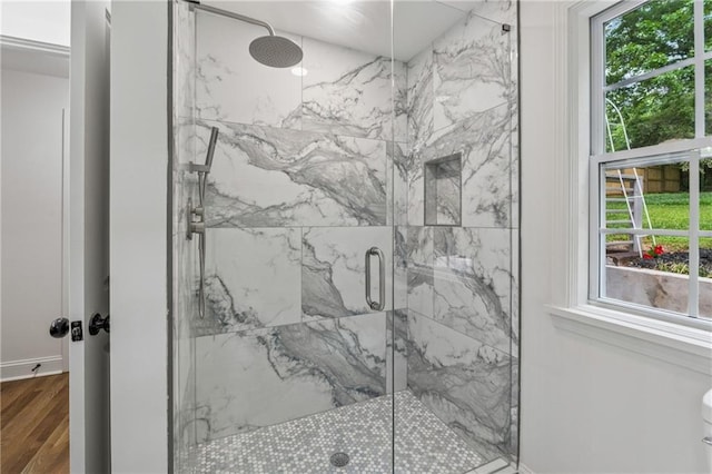 full bathroom with baseboards, wood finished floors, and a marble finish shower