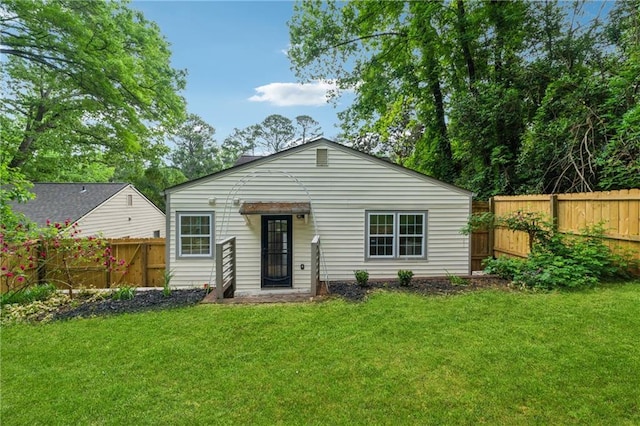 view of front facade with a front lawn and a fenced backyard