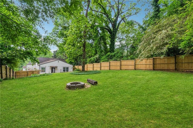 view of yard with a fire pit and a fenced backyard