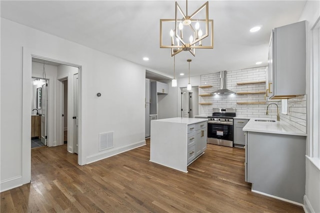 kitchen with open shelves, wall chimney range hood, stainless steel range oven, a sink, and visible vents