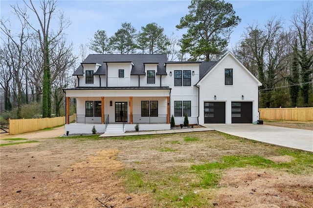 view of front of house featuring a garage, covered porch, and a front lawn