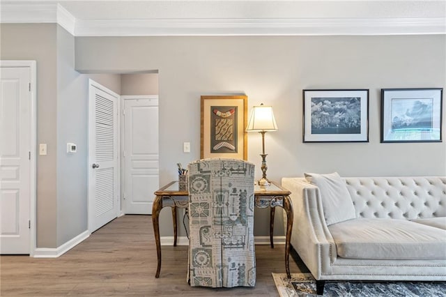 sitting room with wood-type flooring and ornamental molding