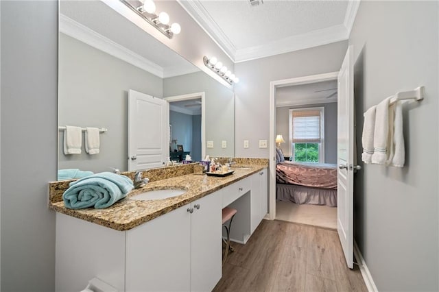 bathroom featuring hardwood / wood-style floors, vanity, a textured ceiling, and ornamental molding