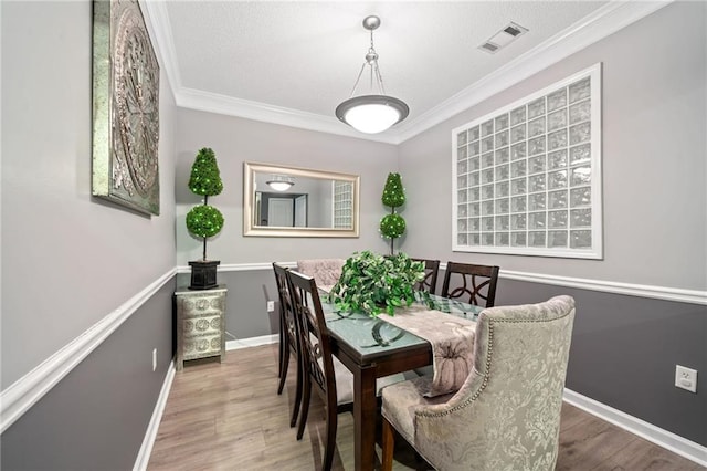 dining room featuring hardwood / wood-style flooring and crown molding