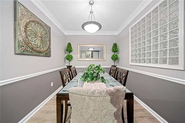 dining space featuring crown molding and light hardwood / wood-style flooring