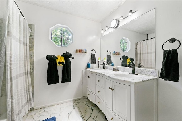 bathroom featuring marble finish floor, a sink, double vanity, and plenty of natural light