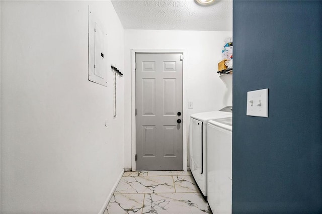 laundry room featuring a textured ceiling, separate washer and dryer, electric panel, marble finish floor, and laundry area