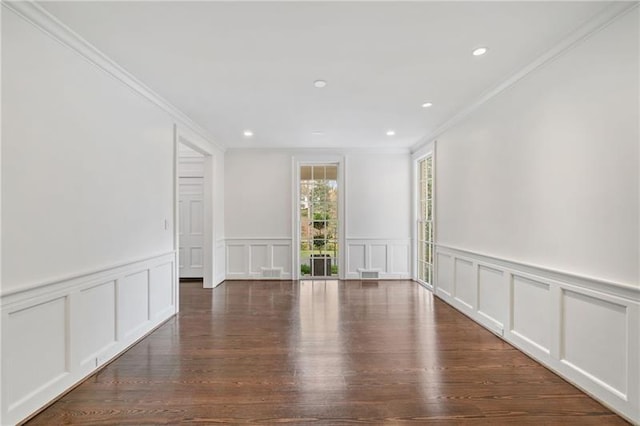 empty room with ornamental molding and dark hardwood / wood-style flooring