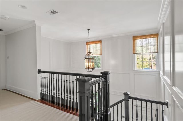 stairs with hardwood / wood-style flooring, ornamental molding, and an inviting chandelier