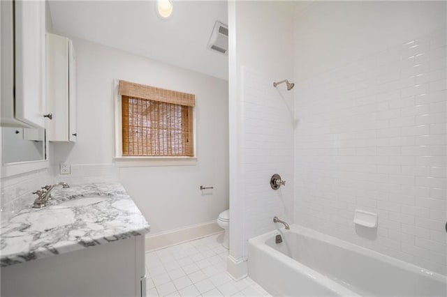 full bathroom featuring vanity, tiled shower / bath, tile patterned floors, and toilet