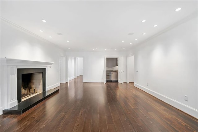 unfurnished living room featuring crown molding and dark wood-type flooring