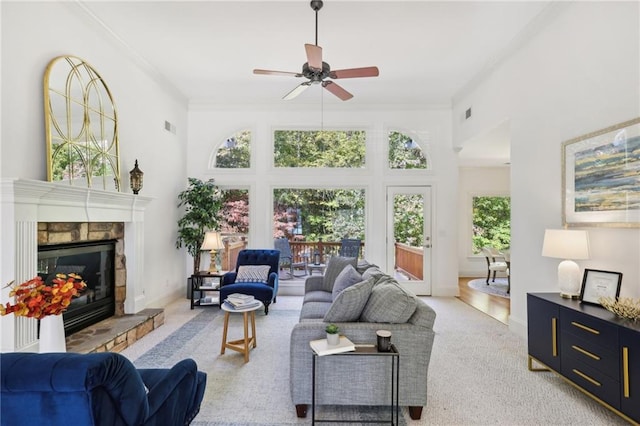 living room featuring crown molding, a healthy amount of sunlight, and a fireplace