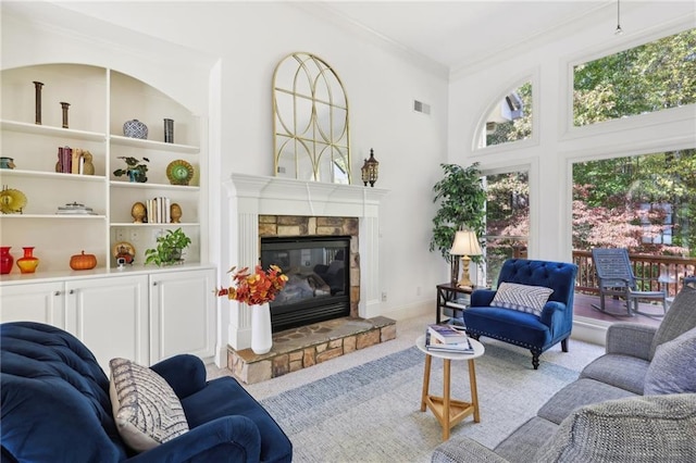 living room featuring light carpet, ornamental molding, a high ceiling, and a fireplace