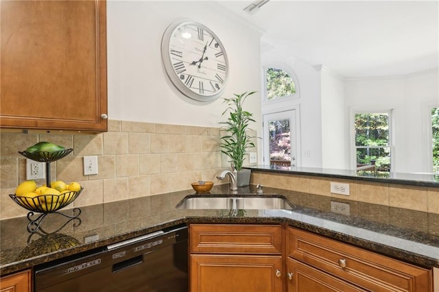 kitchen with tasteful backsplash, dark stone counters, ornamental molding, dishwasher, and sink