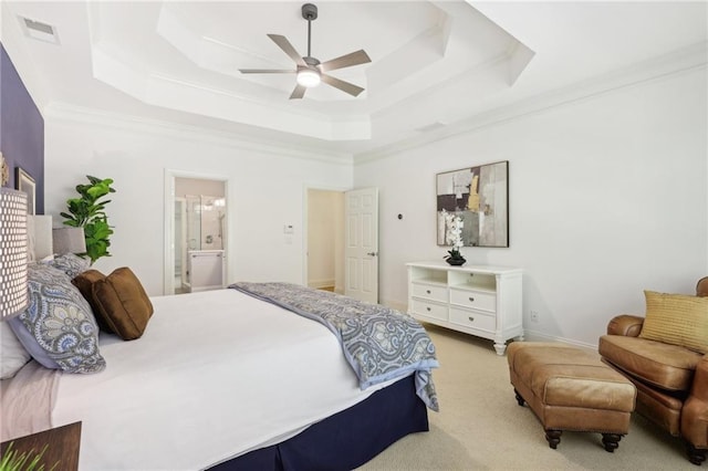 carpeted bedroom with ensuite bathroom, a raised ceiling, ornamental molding, and ceiling fan