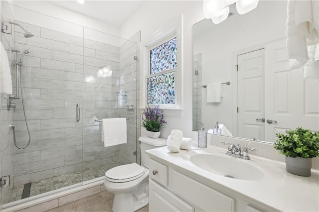 bathroom with toilet, a shower with shower door, vanity, and tile patterned floors