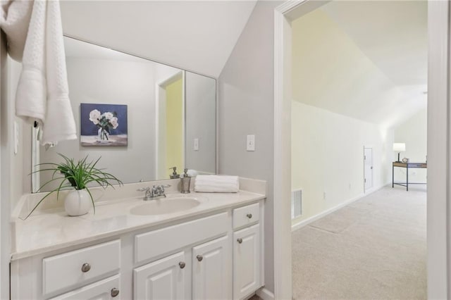 bathroom featuring vanity and lofted ceiling