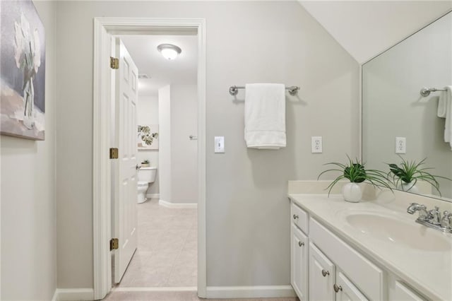 bathroom featuring vanity, tile patterned flooring, toilet, and vaulted ceiling