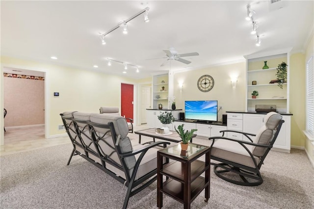 carpeted living room with crown molding, built in shelves, and ceiling fan