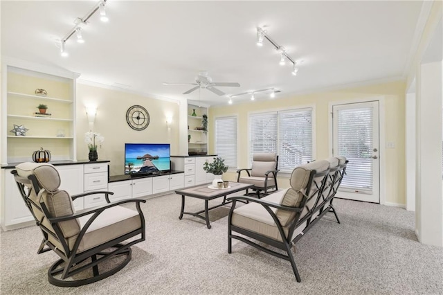 carpeted living room with crown molding and ceiling fan