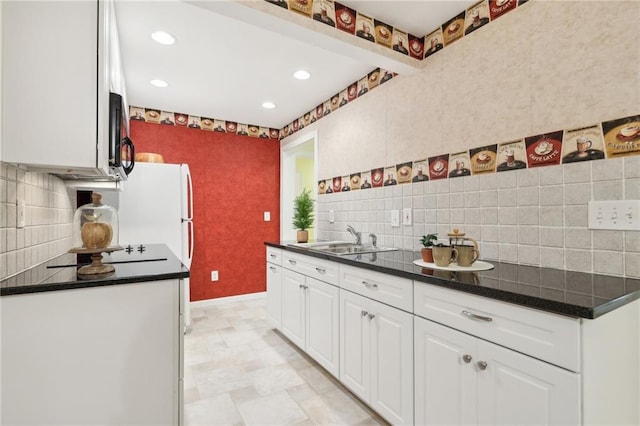 kitchen with white cabinetry, black appliances, sink, and backsplash