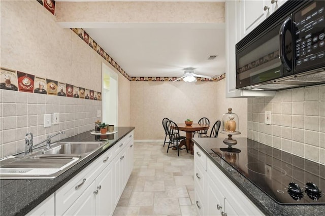 kitchen with sink, black appliances, white cabinets, and backsplash