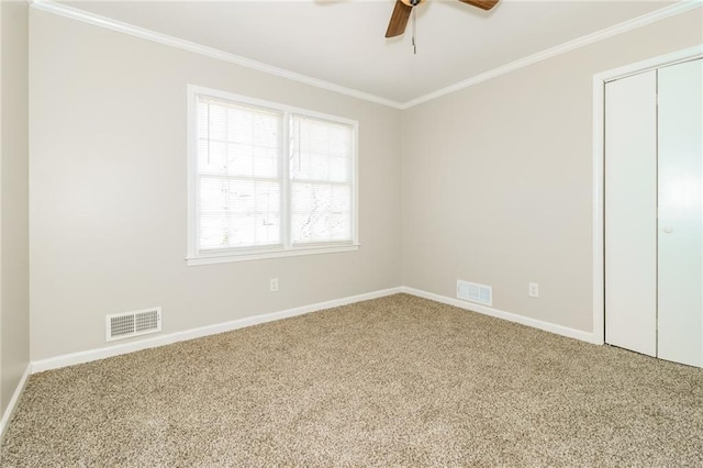 unfurnished bedroom featuring crown molding, carpet flooring, baseboards, and visible vents